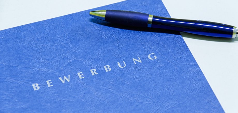 Auf einer Bewerbungsmappe liegt ein Kugelschreiber