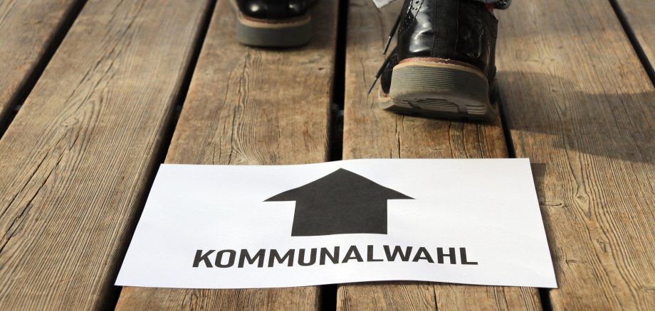 Laufende Person, hinter ihm liegt ein Schild mit Kommunalwahl