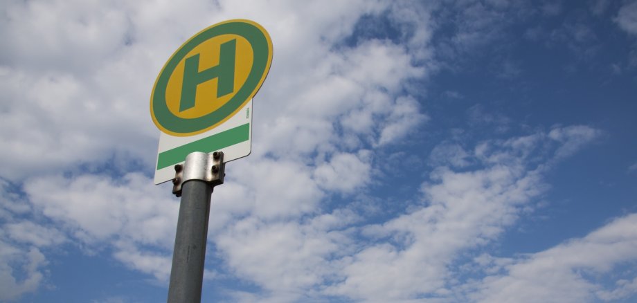 Zeichen für Bushaltestelle vor blauen Himmel mit Wolken