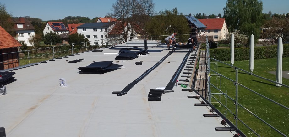 Dach Solarabsorberanlage Sonnenschirme Gras Gerüst Häuser Bäume