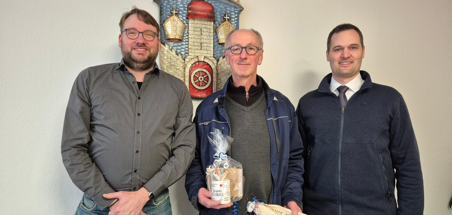 Markus Sälzer und Jürgen Werner und Bürgermeister Sebastian Lesch stehen vor dem Stadtwappen der Stadt Naumburg