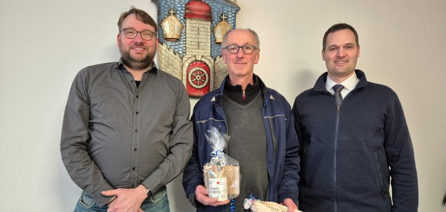 Markus Sälzer und Jürgen Werner und Bürgermeister Sebastian Lesch stehen vor dem Stadtwappen der Stadt Naumburg