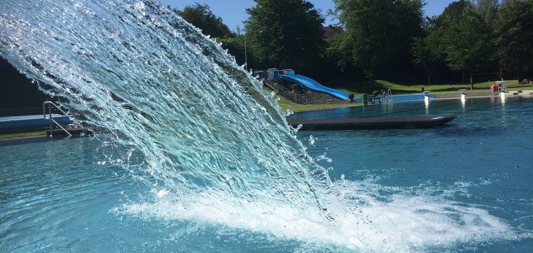Freibad Naumburg und im Vordergrund eine Wasserfontaine