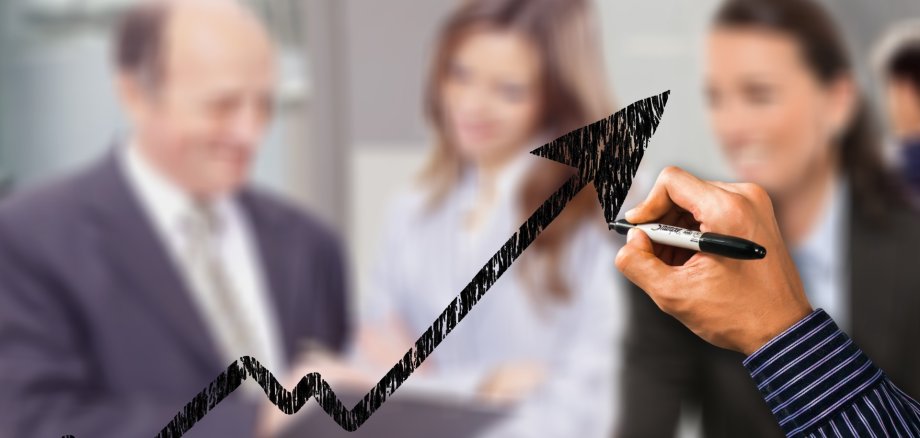 Eine Hand zeichnet einen Pfeil