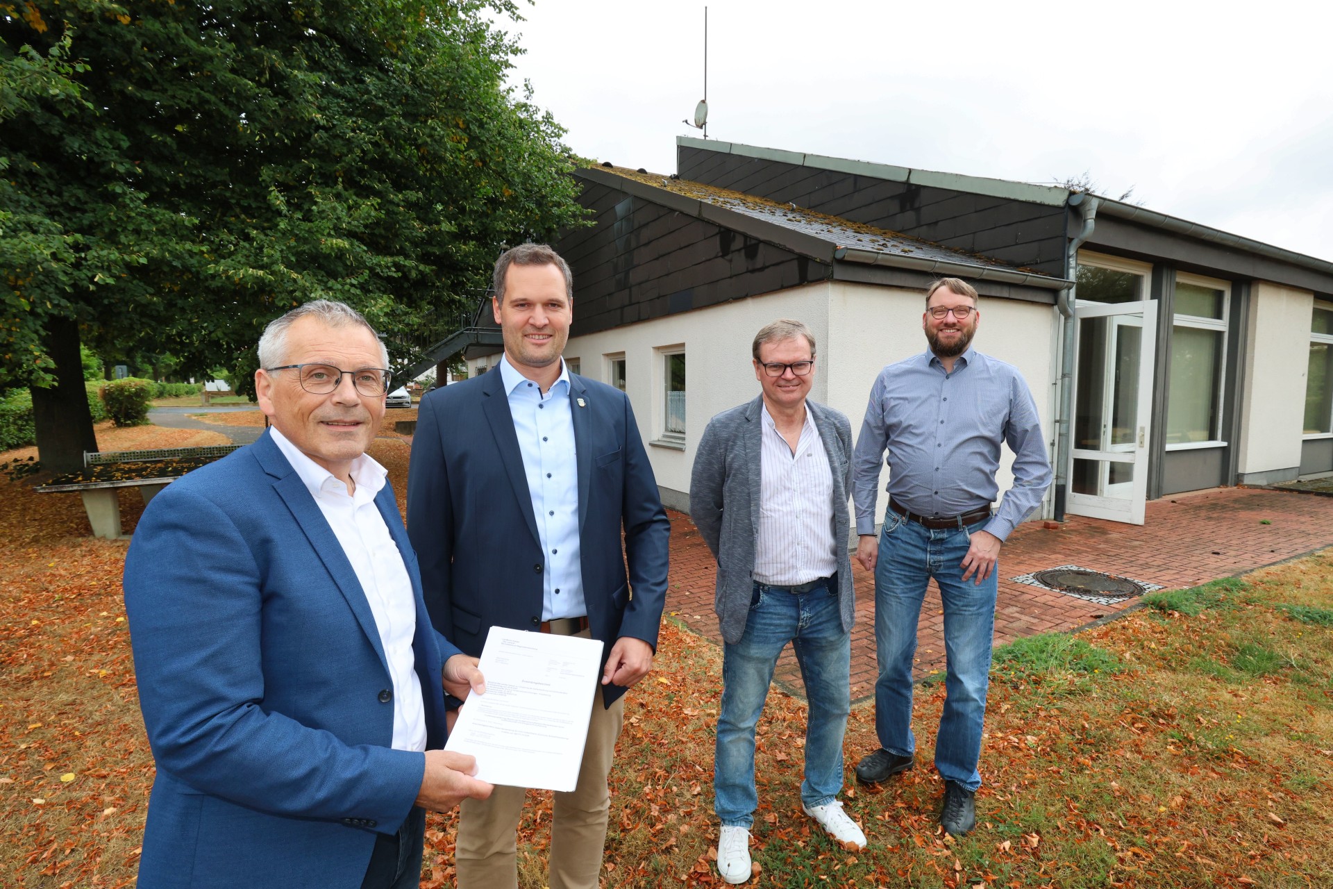 Personen stehen vor dem Dorfgemeinschaftshaus Heimarshausen