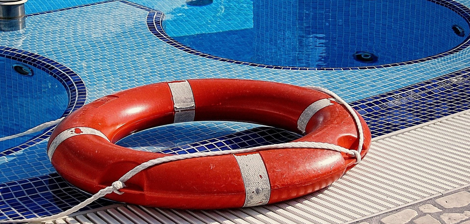Ein Rettungsring liegt am Beckenrand im Schwimmbad.