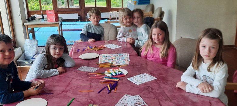 Vorschulkinder basteln Namensschilder an einem Tisch