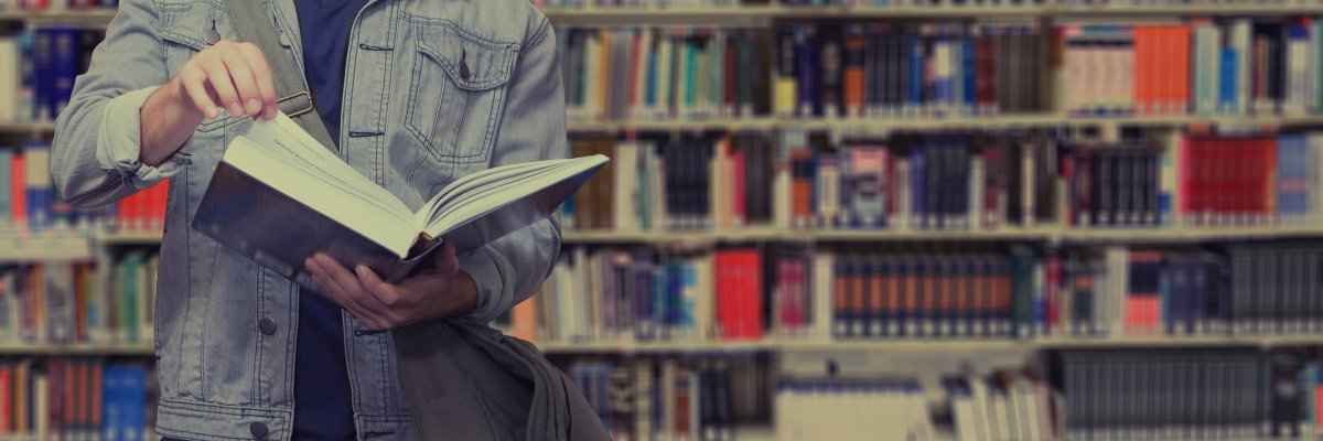 Eine Person hält ein offenes Buch in der Hand