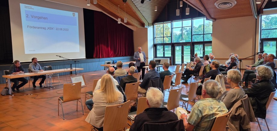 Mehrere Personen sitzen im Haus des Gastes