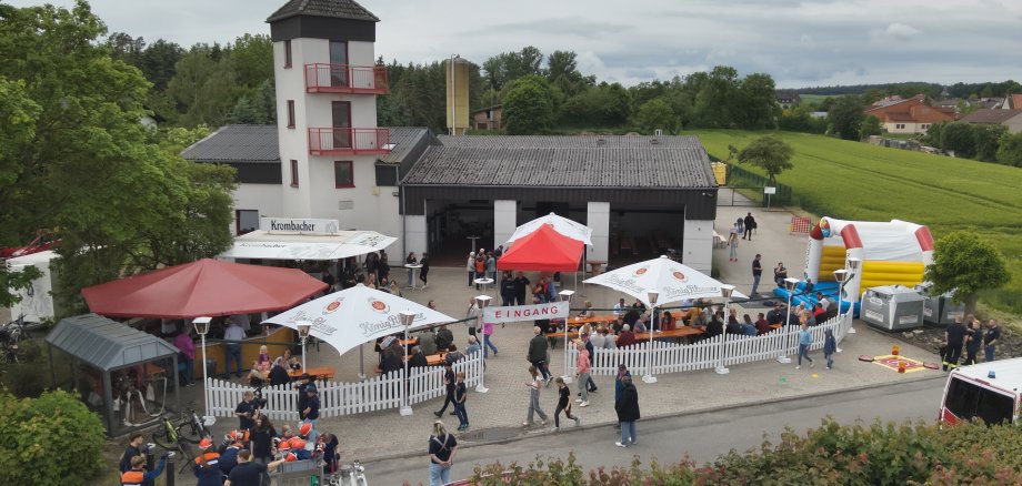 Feuerwehrhaus Zäune Schirme Personen Himmel Straße Hüpfburg