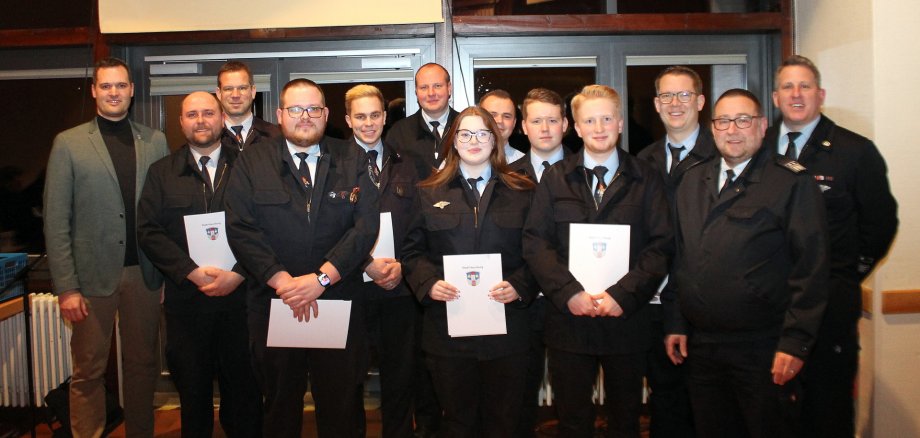 Gruppenbild der beförderten Feuerwehrfrau und Feuerwehrmänner. 