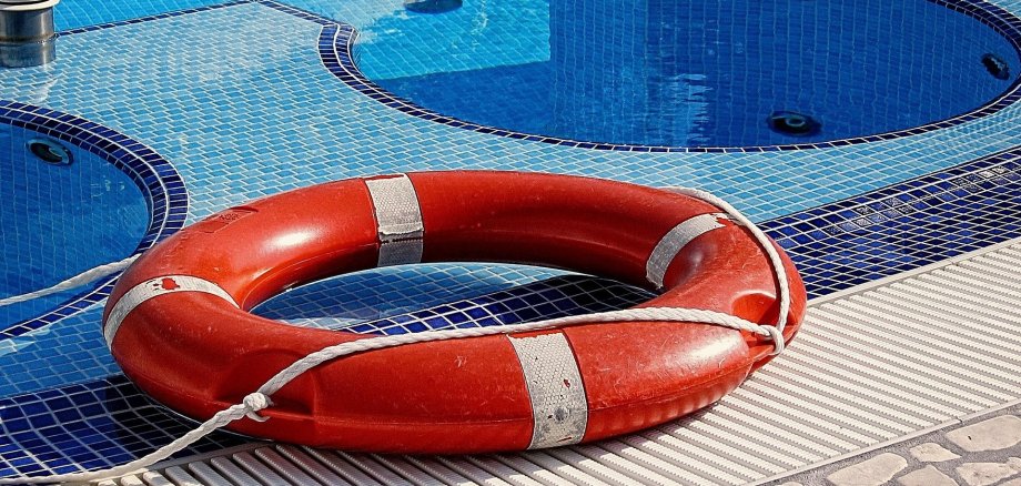 Ein Rettungsring liegt am Beckenrand im Schwimmbad.