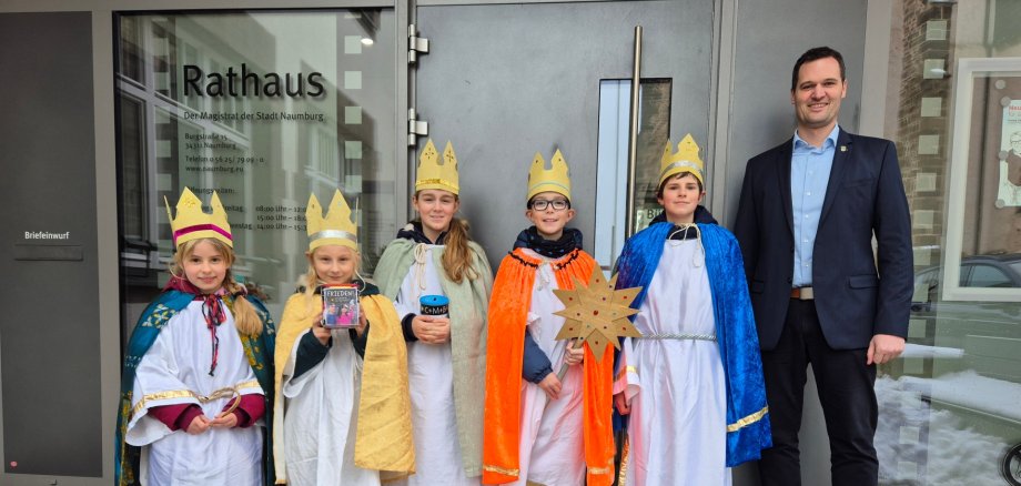 Die fünf Sternsinger mit Bürgermeister Sebastian Lesch vor dem Rathaus